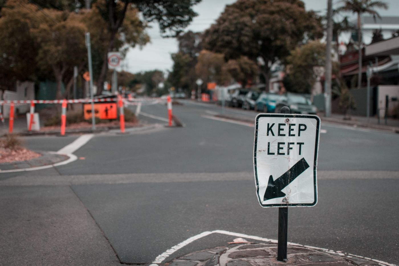 Keep Left sign at a Melbourne intersection with temporary barriers and roadwork signage behind