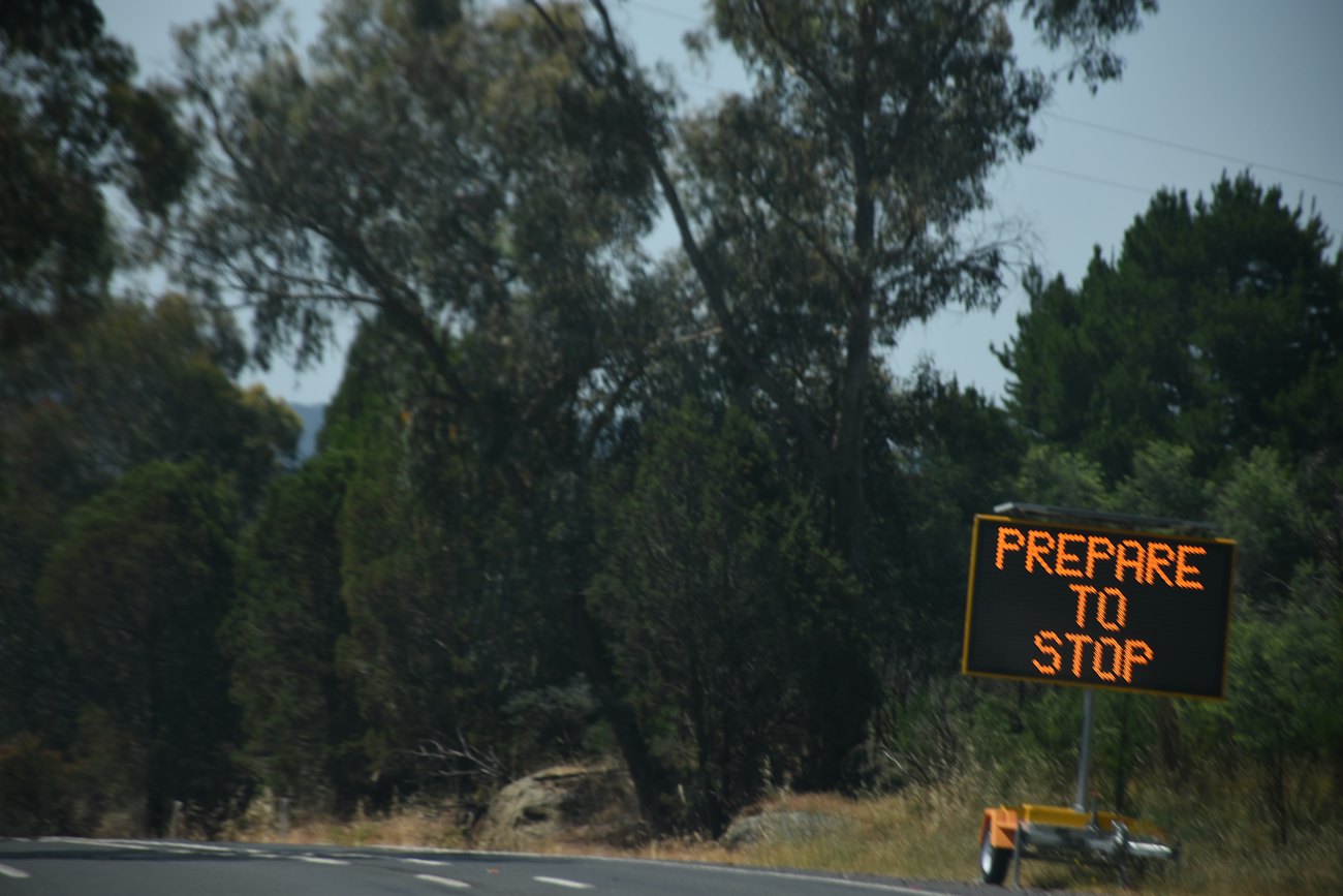 Variable message sign reading Prepare to Stop beside a bushland road
